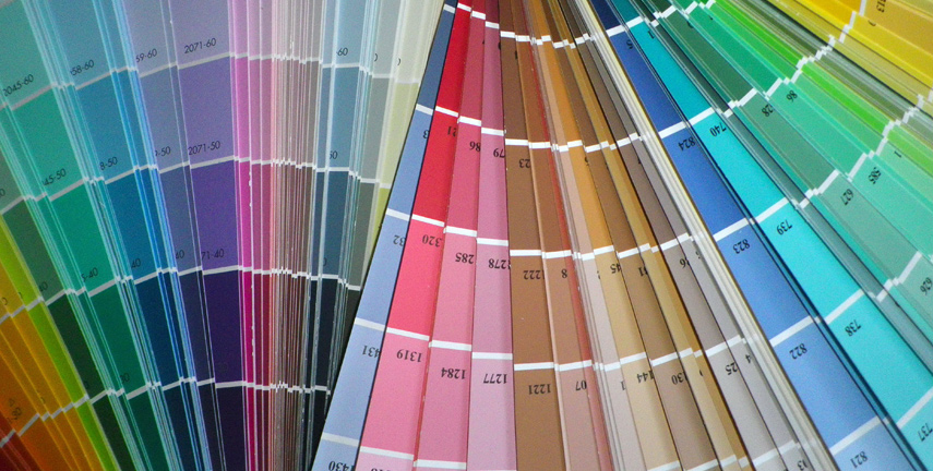 The image displays a fan deck of various paint swatches in an array of colours, including shades of purple, pink, red, brown, and green. The cards are arranged in a circular pattern, allowing easy comparison of hues.